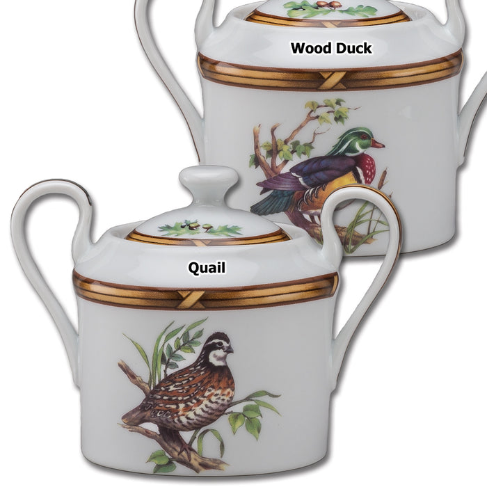 Porcelain sugar bowls with lids featuring quail and wood duck illustrations and elegant gold-toned rim detailing.