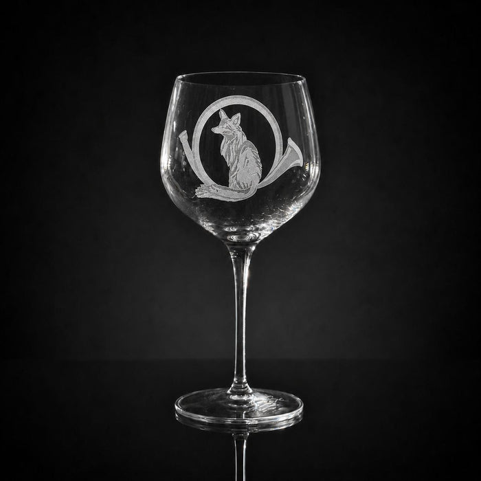 18 oz crystal red wine glass featuring a hand-carved fox and horn design on a clear glass bowl against a black background.