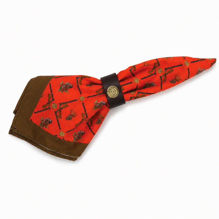 Brown leather napkin ring featuring a brass shotshell concho, holding an orange hunting-themed cloth napkin.