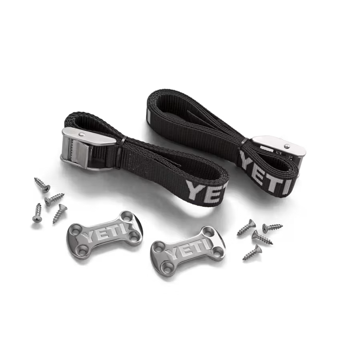 YETI tie-down kit with two black nylon straps, metal buckles, two low-profile deck plates, and mounting screws.