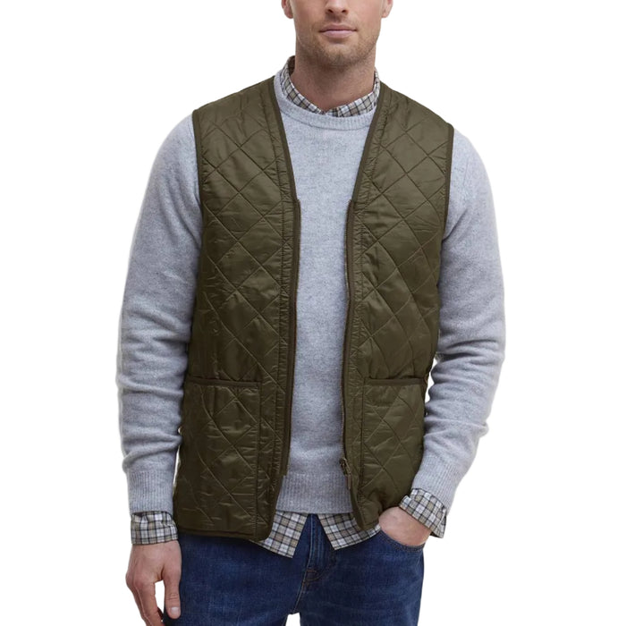 Olive green Barbour diamond-quilted nylon vest with a zip-front closure and two patch pockets worn over a grey sweater.