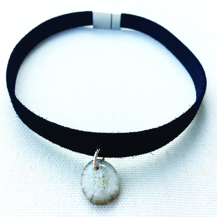 Black suede choker necklace featuring a natural antler slice pendant and a secure magnetic clasp.