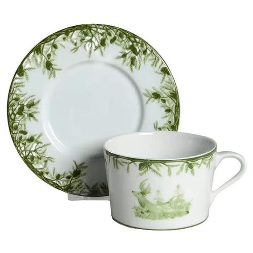 Porcelain 11 oz cup and saucer featuring a green deer and forest pine motif on a white background.