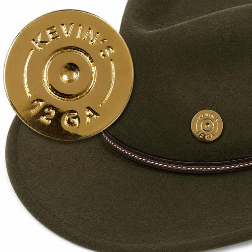 Polished brass 12-gauge shotgun shell hat pin attached to a dark olive felt hat with a brown leather band.