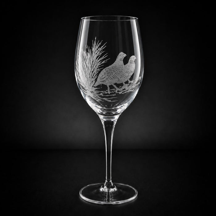 11 oz crystal white wine glass featuring a hand-etched, multi-layered design of two quail in a field against a black background.