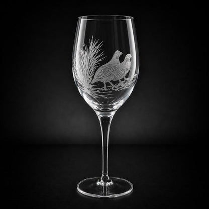 11 oz crystal white wine glass featuring a hand-etched, multi-layered design of two quail in a field against a black background.