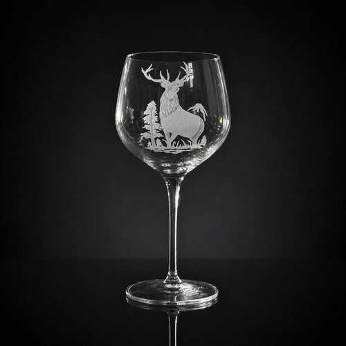 18 oz crystal red wine glass featuring a detailed, hand-carved elk and forest motif against a black background.