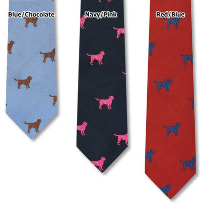 Handcrafted silk ties in blue, navy, and red featuring repeating Labrador retriever dog patterns in contrasting colors.