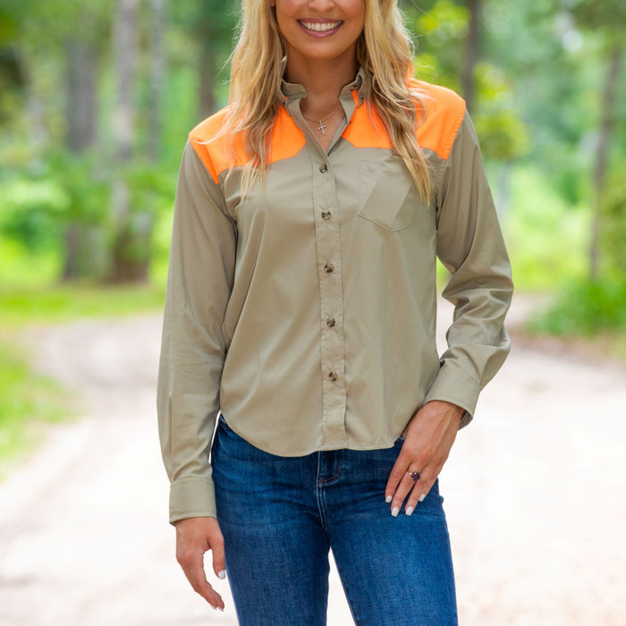 Tan long-sleeve cotton shooting shirt with bright orange shoulder patches and button-down collar worn with blue jeans.