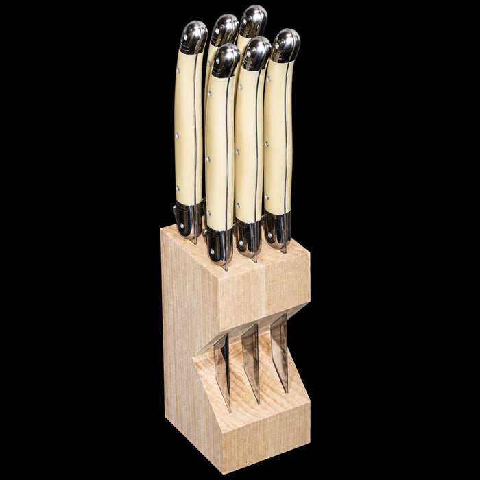 Set of six Laguiole steak knives with ivory ABS handles and stainless steel bolsters in a natural beechwood block.