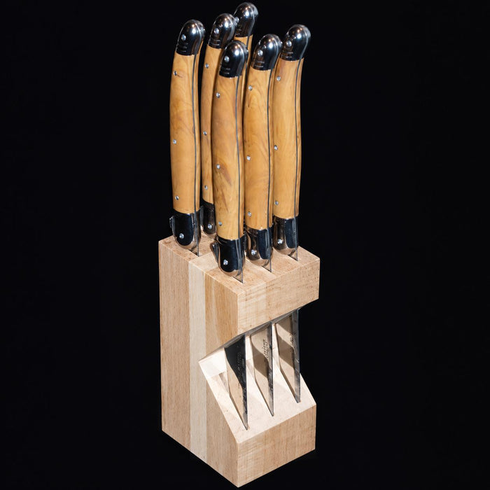 Set of six Laguiole steak knives with olive wood handles and stainless steel bolsters in a beechwood block.
