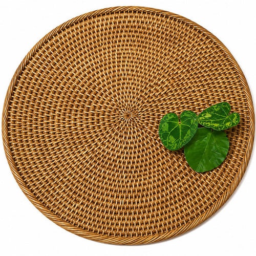 14-inch round handwoven Burmese rattan placemat in a natural tan finish with green decorative leaves.