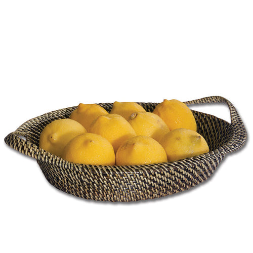 Handwoven oval wicker basket with handles filled with fresh yellow lemons, featuring a durable, tight-weave vine finish.