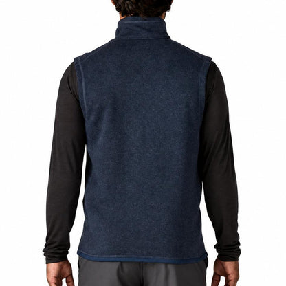 Back view of a navy blue Patagonia Better Sweater fleece vest with a stand-up collar worn over a black long-sleeve shirt.
