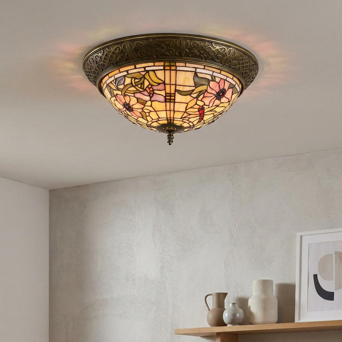 Pavot Flush Tiffany Ceiling Light with pink floral stained glass and bronze trim on a white ceiling.