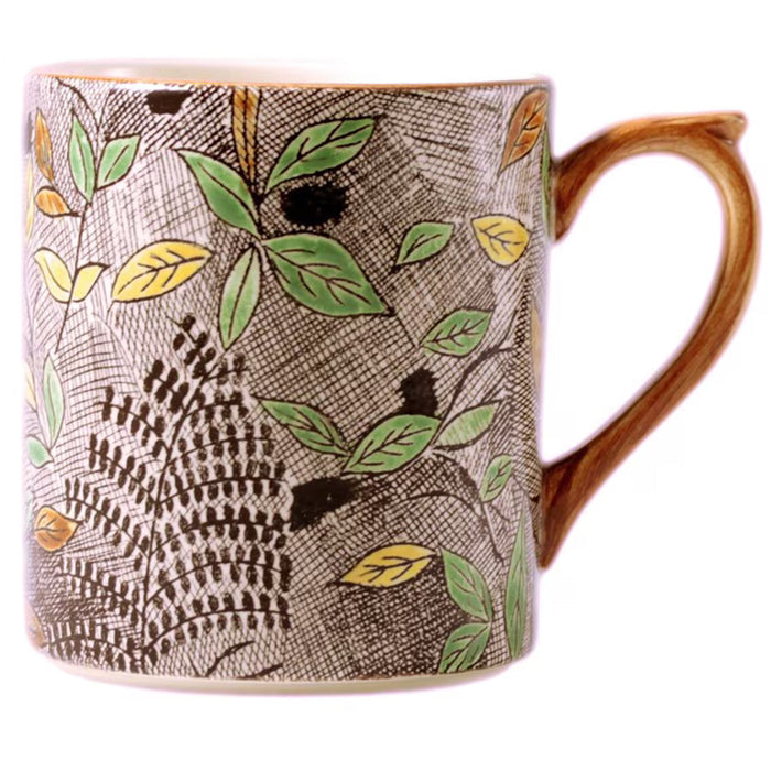 Gien Rambouillet faïence mug with hand-painted green and yellow foliage pattern on a textured grey cross-hatch background.
