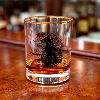 14 oz double old fashioned glass with a gold rim and black Richard E. Bishop sporting dog illustration.