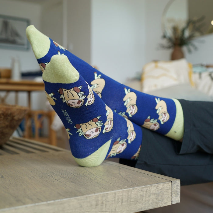blue sloth bamboo socks on a wooden table in a living room setting