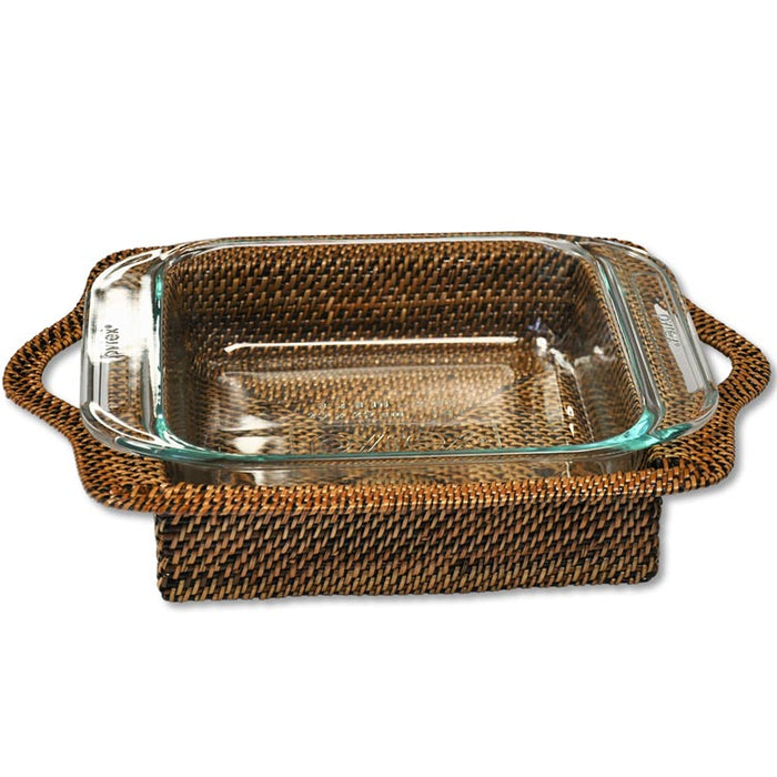 Square glass baking dish nestled in a handcrafted, dark brown woven watervine holder with side handles.