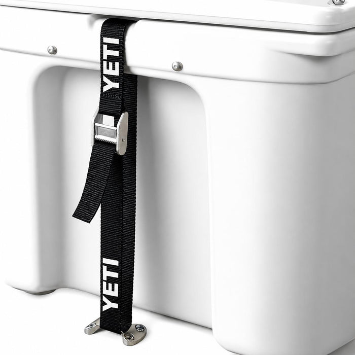 Black YETI tie-down strap with metal buckle secured to a white cooler and a low-profile stainless steel deck plate.