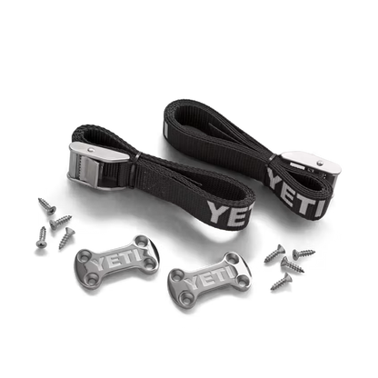 YETI tie-down kit with two black nylon straps, metal buckles, two low-profile deck plates, and mounting screws.